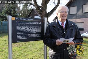 Gerd Schug vor der Hinweistafel zum Pestkreuz.jpg