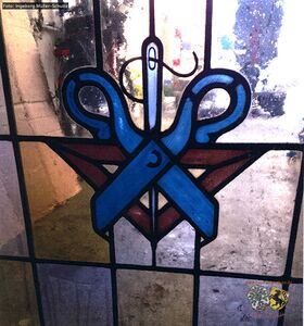 Fenster mit Zunftzeichen der Schneider Innung.