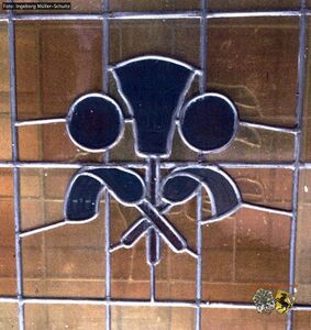 Fenster mit Zunftzeichen der Schornsteinfeger Innung.