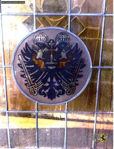 Fenster mit Zunftzeichen der Schumacher Innung.